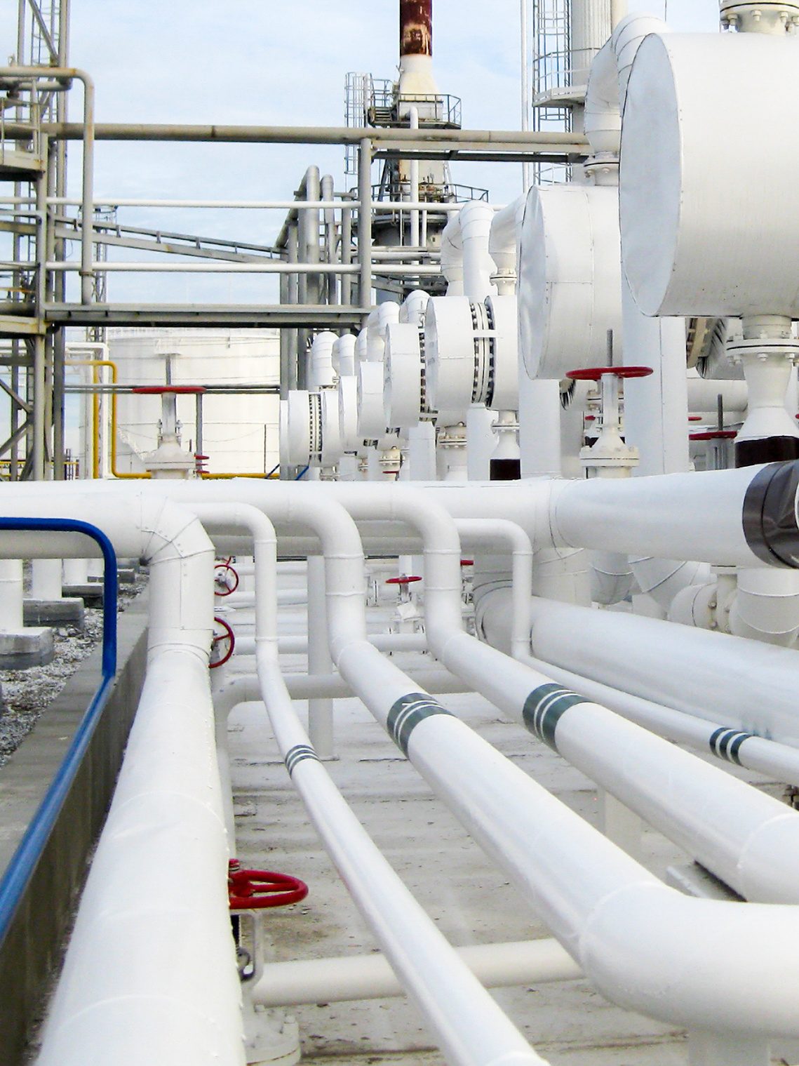 Insulated process piping with red valve wheels at a plant