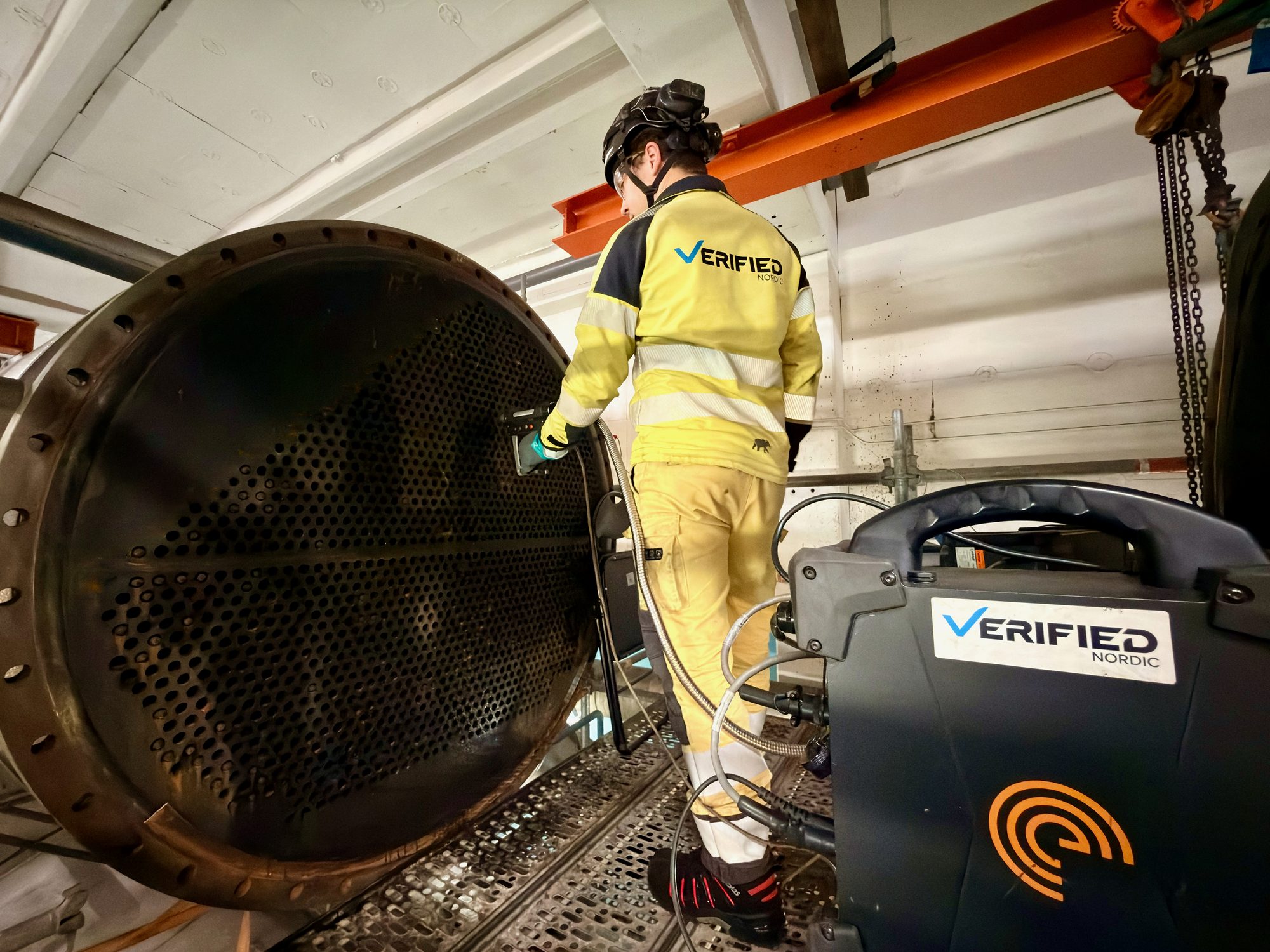 Verified Nordic inspector testing tubes at an open heat-exchanger face